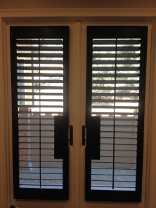 open shutters covering french doors with cutouts for the door handles