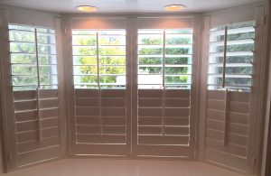 plantation shutters provide privacy for bay windows